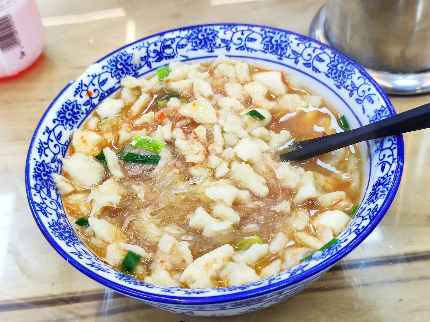 A finished bowl containing many small bread pieces in soup.