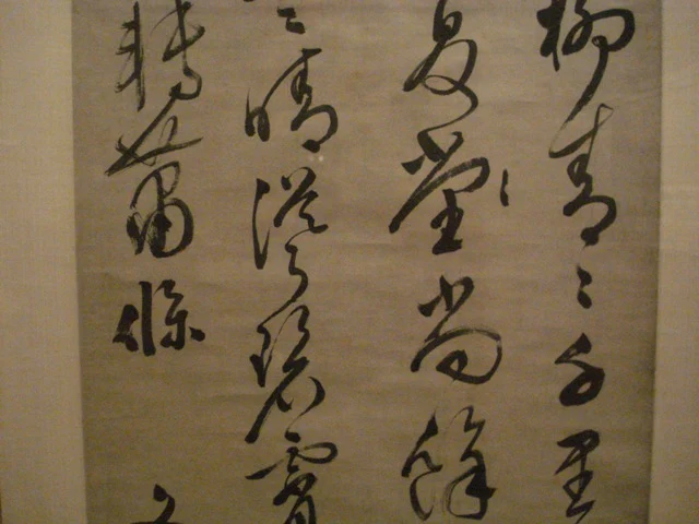 Flowing black brush-written Chinese characters on an aged paper surface.