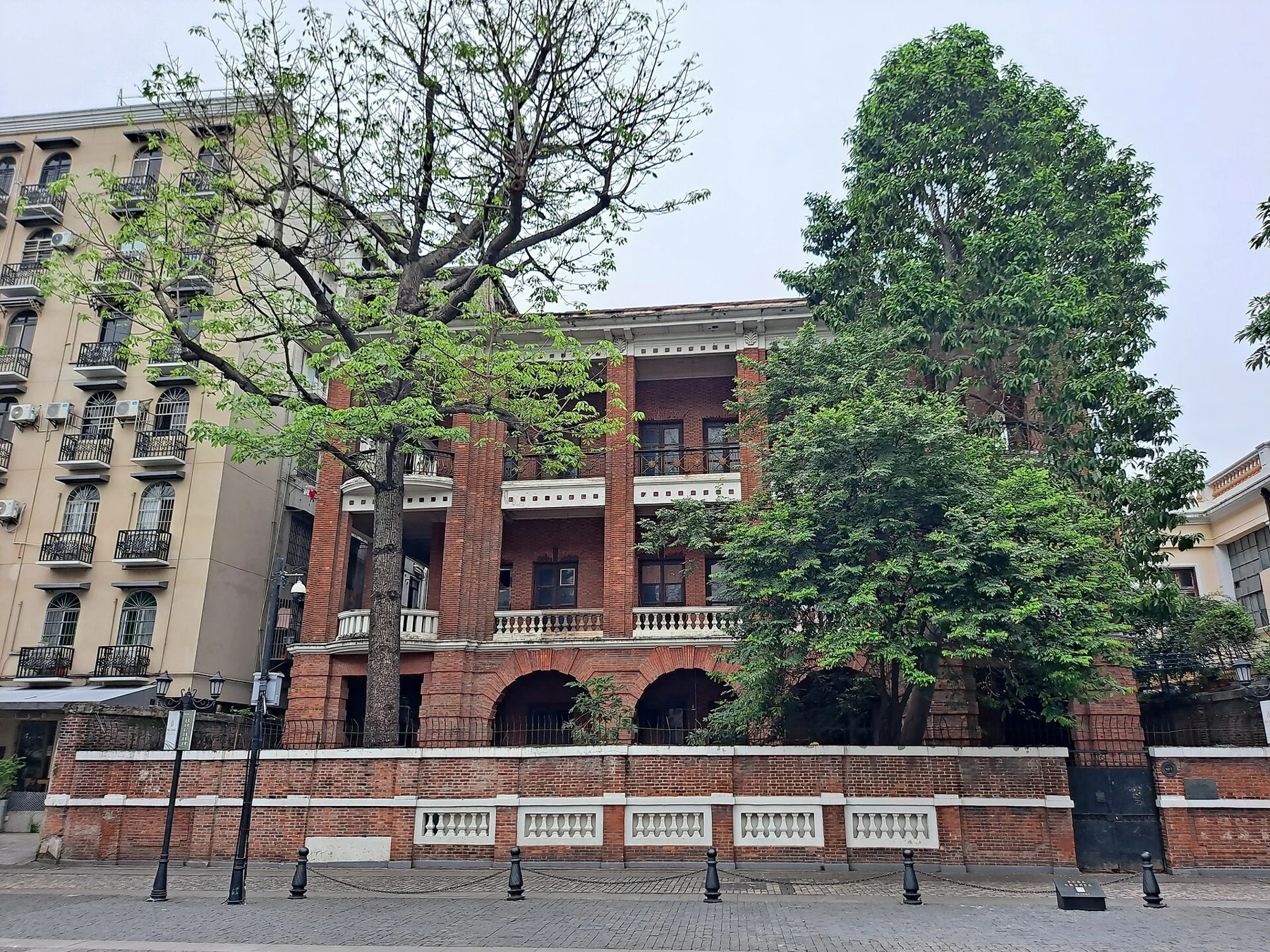 Red-brick building with deep verandas and a front wall at No. 68 Shamian Street.