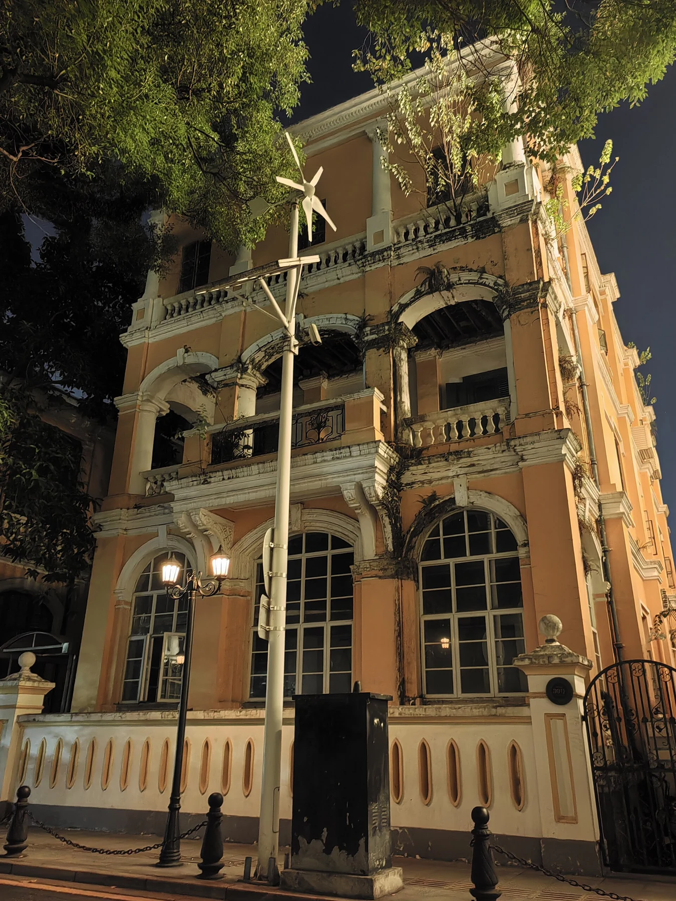 Night-time exterior of a tall building front with arched lower openings at No. 30 Shamian South Street.