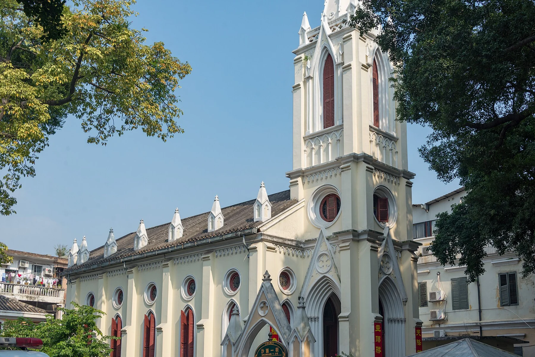 Earlier daylight view of the pale church tower and its long side elevation.