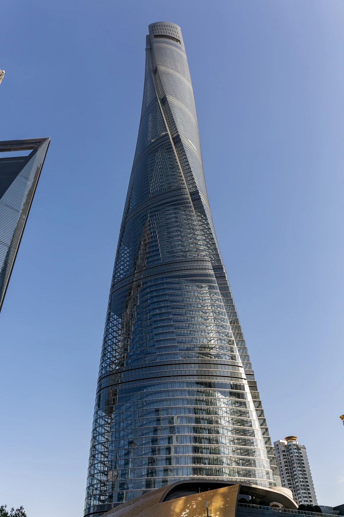 Upward view of Shanghai Tower’s twisting facade and broad base.