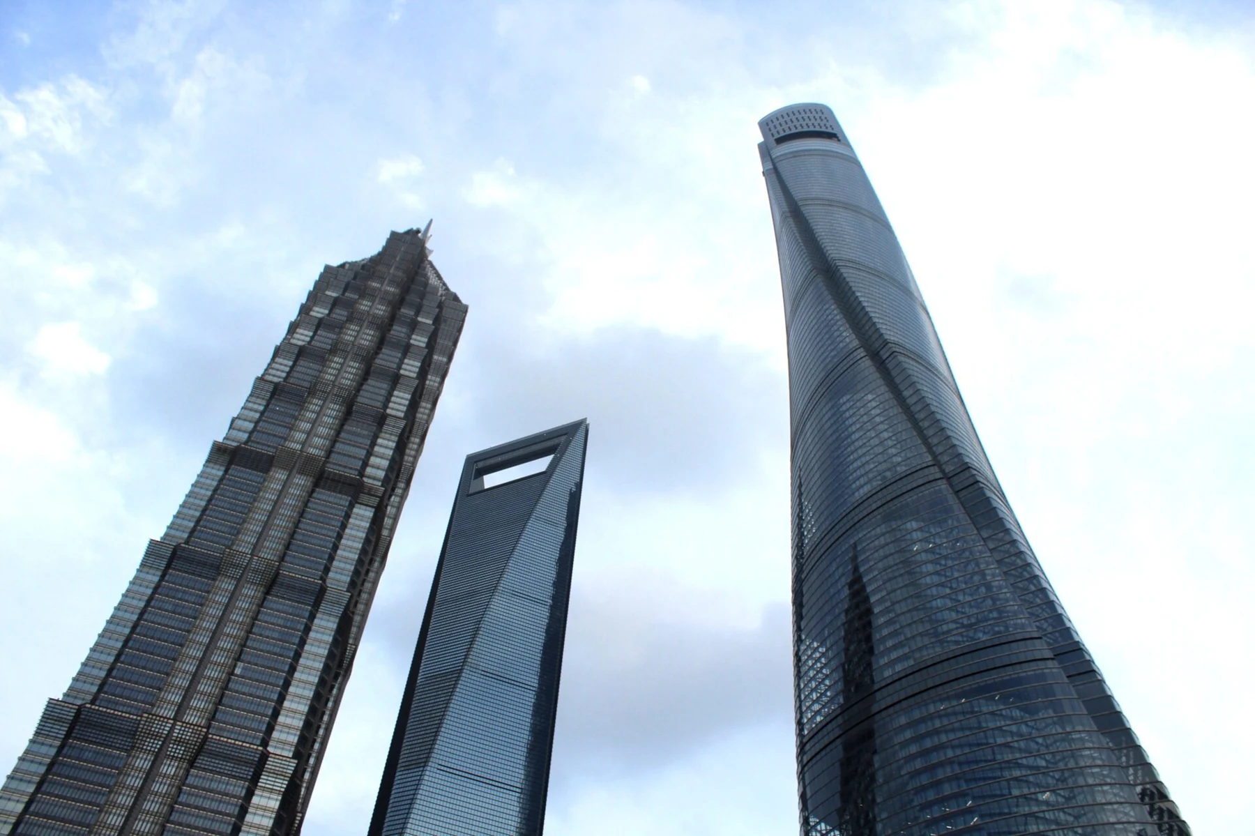 Three contrasting skyscrapers seen from a low public-space viewpoint.