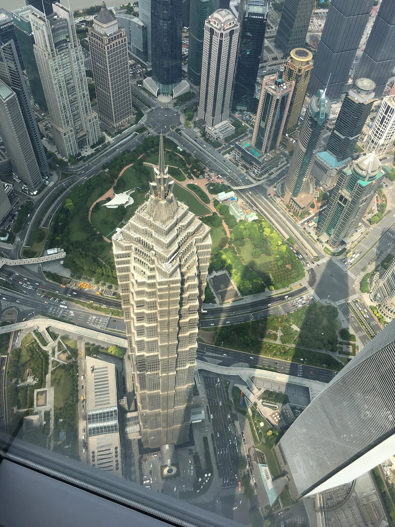 Jin Mao’s stepped top and the city below, partly overlaid by real window reflections.