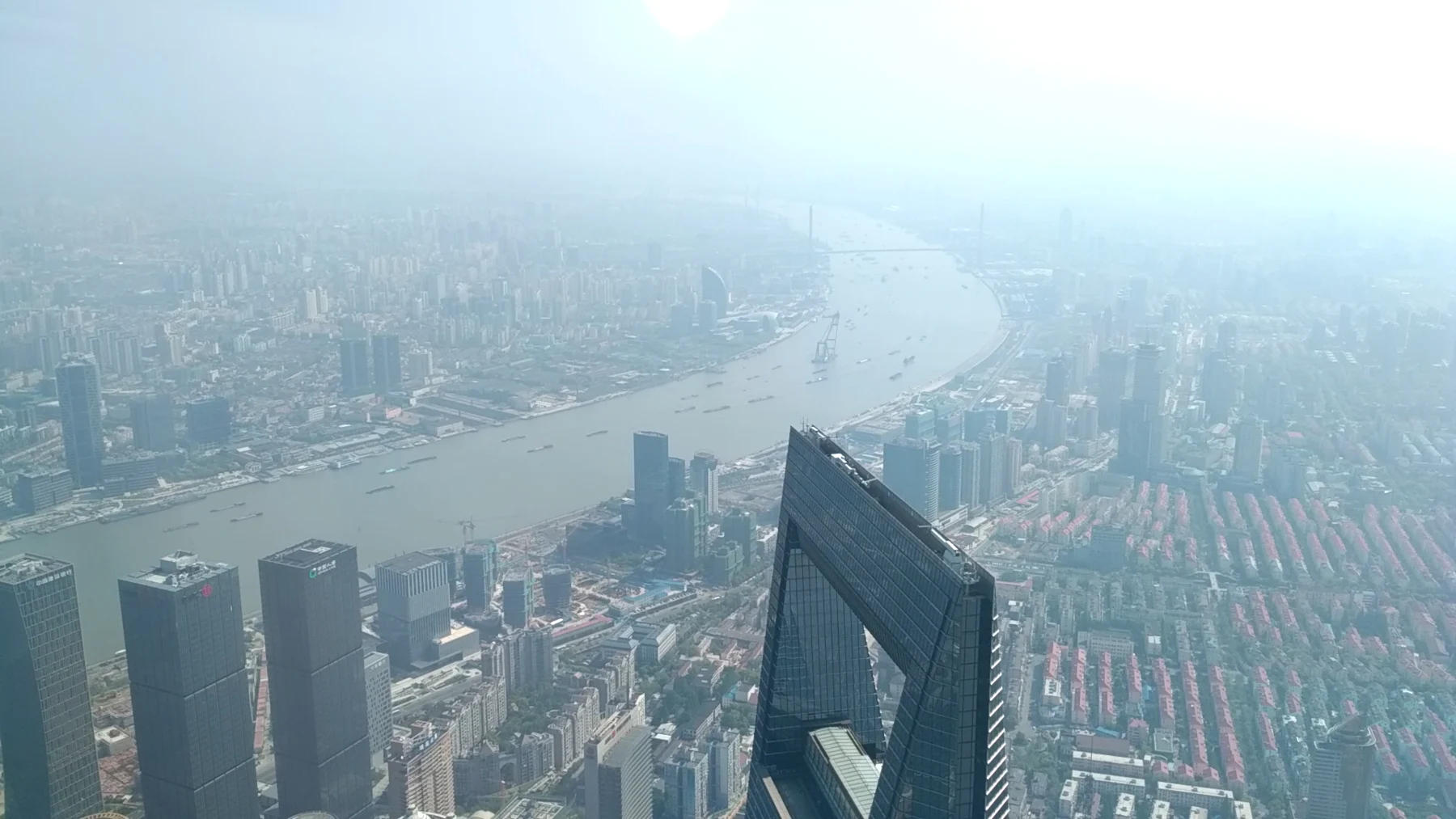World Financial Center’s upper opening and neighbouring towers beneath a hazy horizon.