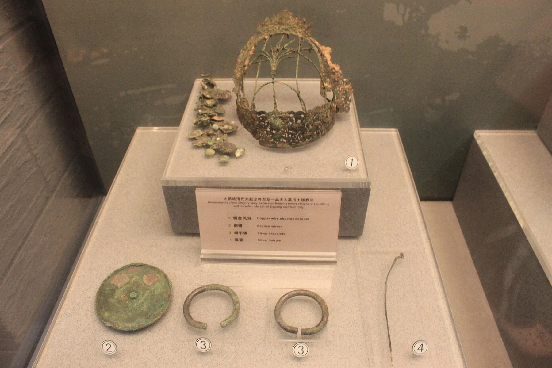Openwork coronet above a bronze mirror, two bracelets and a long hairpin