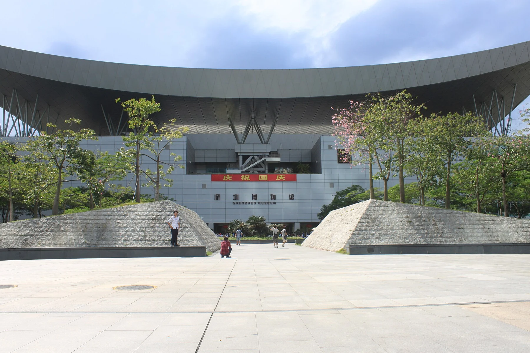 Trees, steps and the broad Civic Center roof above the museum approach
