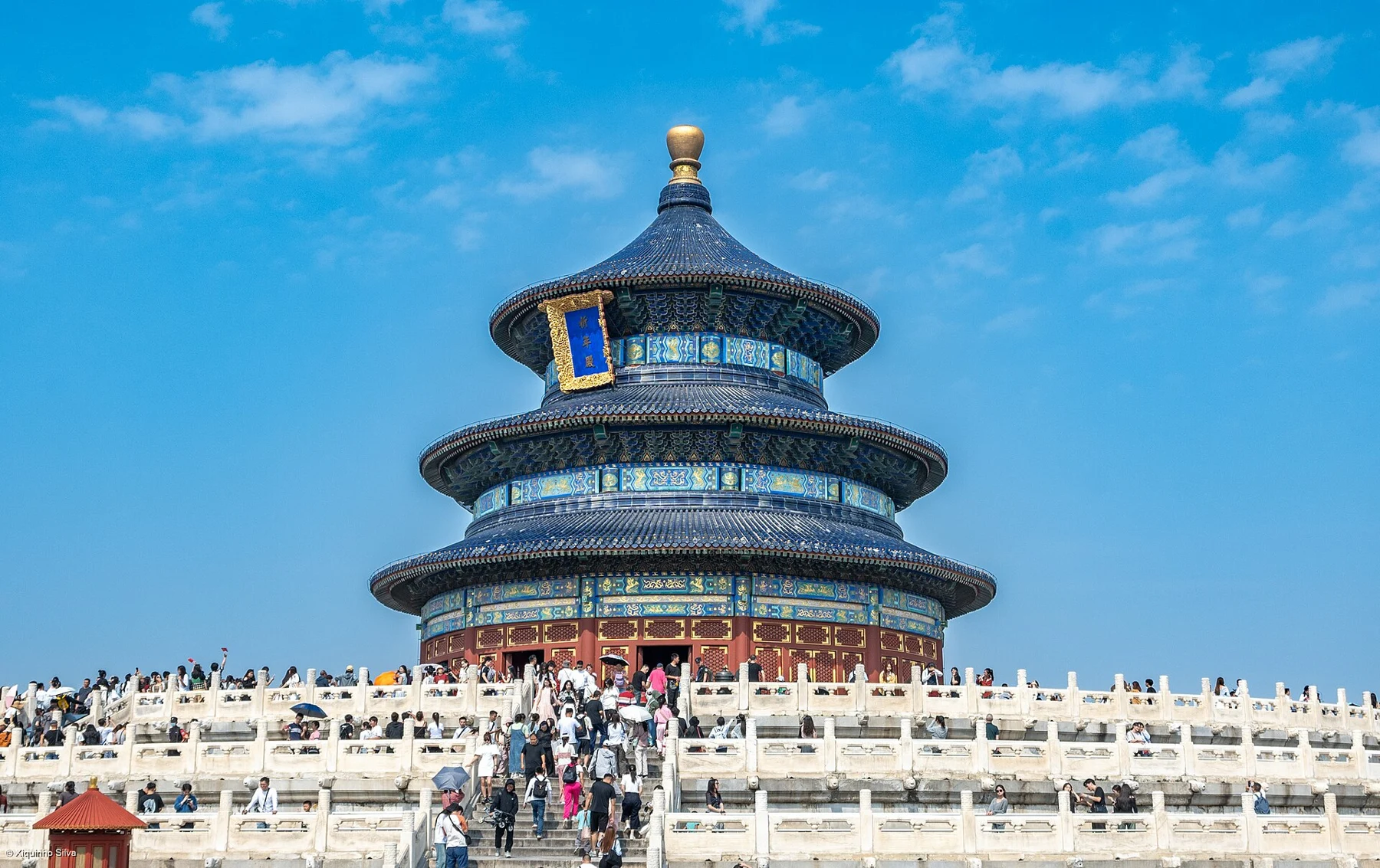The circular, triple-eave Hall of Prayer for Good Harvests, with a blue roof, red walls and visitors on the terrace.