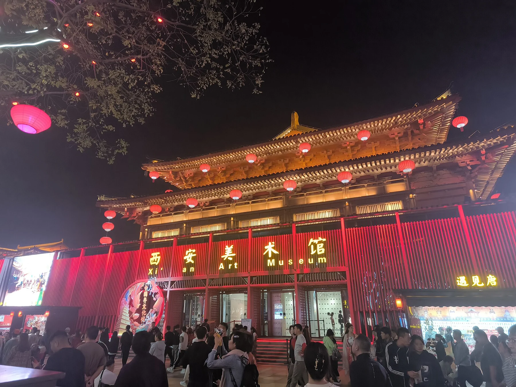 The gold 西安美术馆 and Art Museum signs on a red-lit building facade.