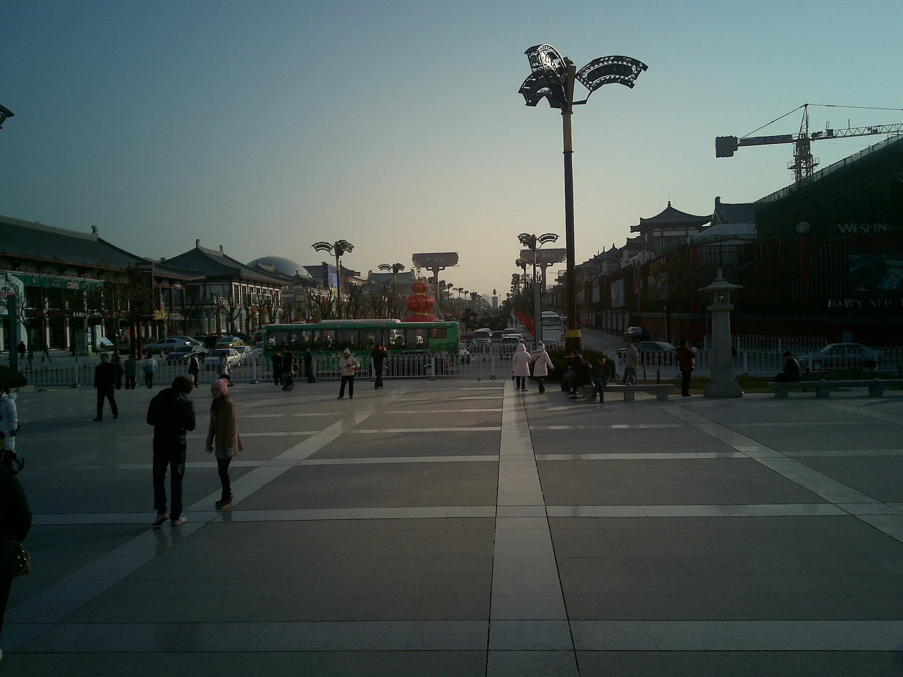 A broad paved public street with ornamental light poles and buildings on either side.