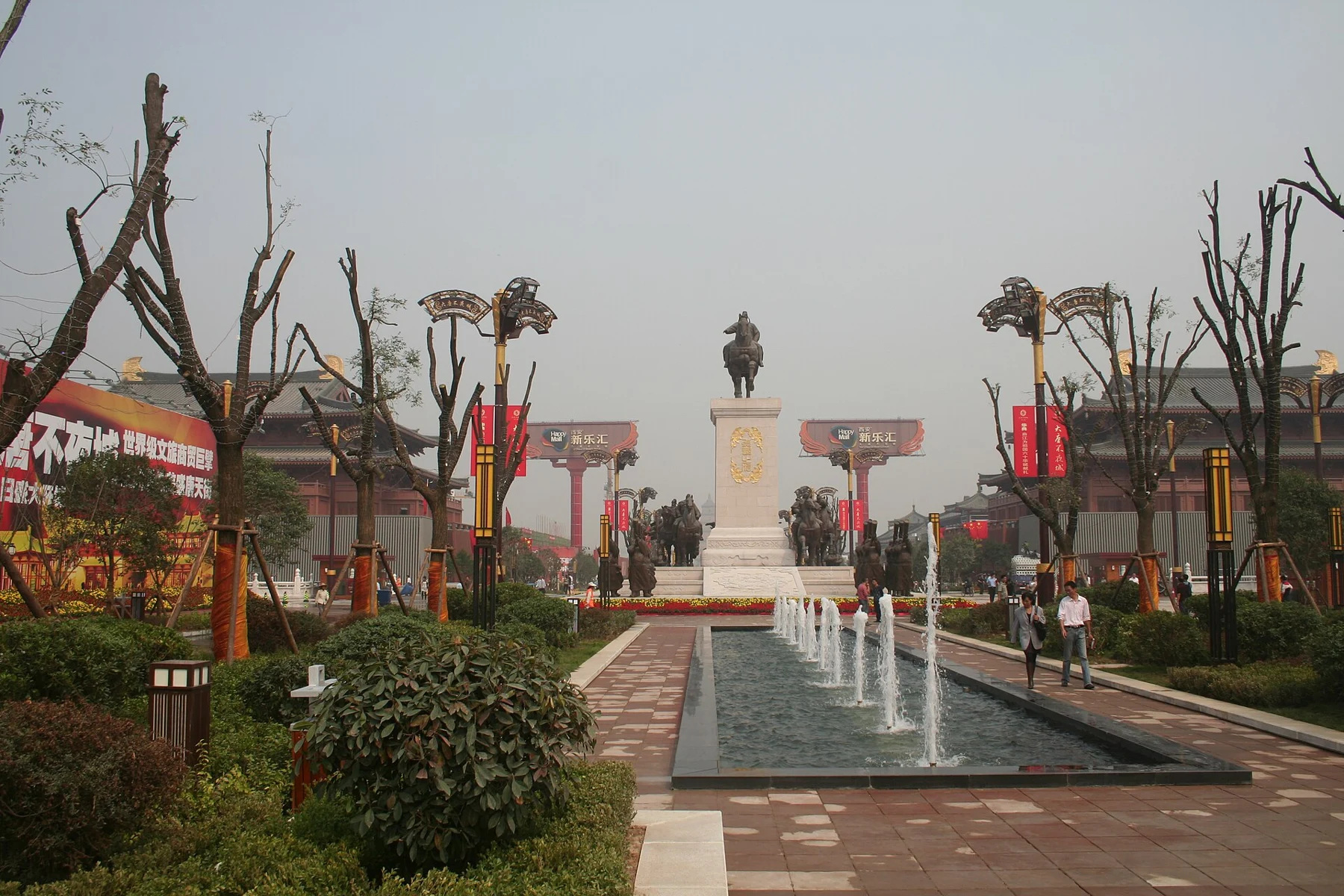 A landscaped street axis looking towards a mounted figure raised on a tall pale column.