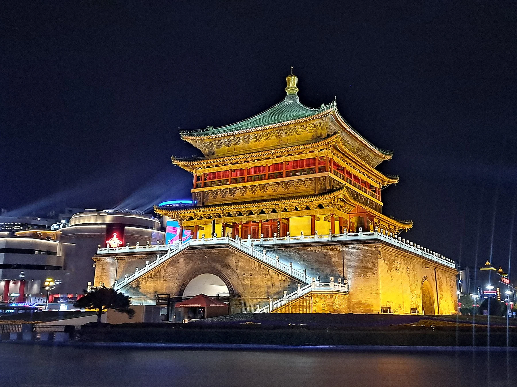 Illuminated Bell Tower above its square masonry base at night.
