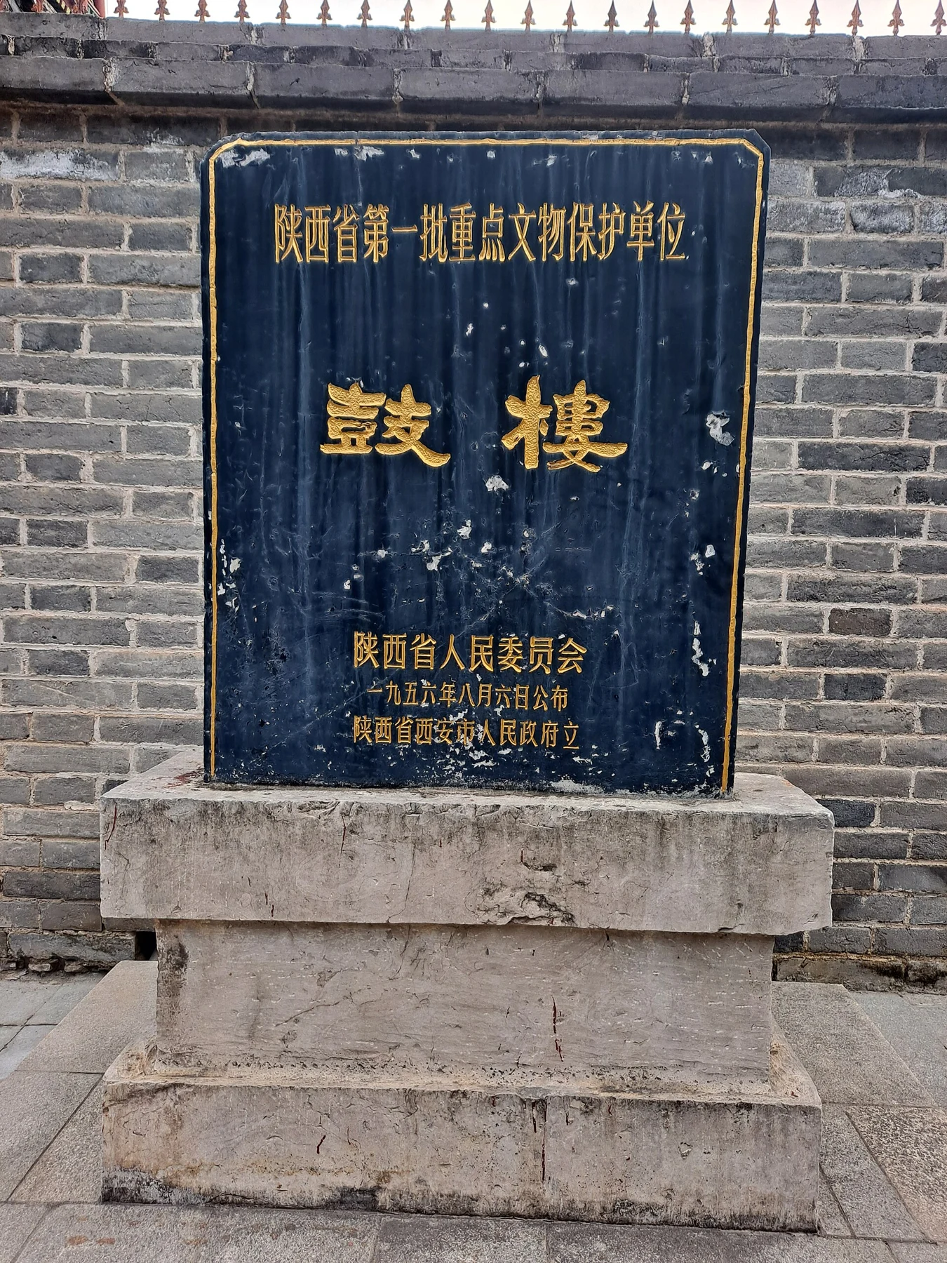 A blue protected-monument plaque reading 鼓楼 mounted into a brick wall.