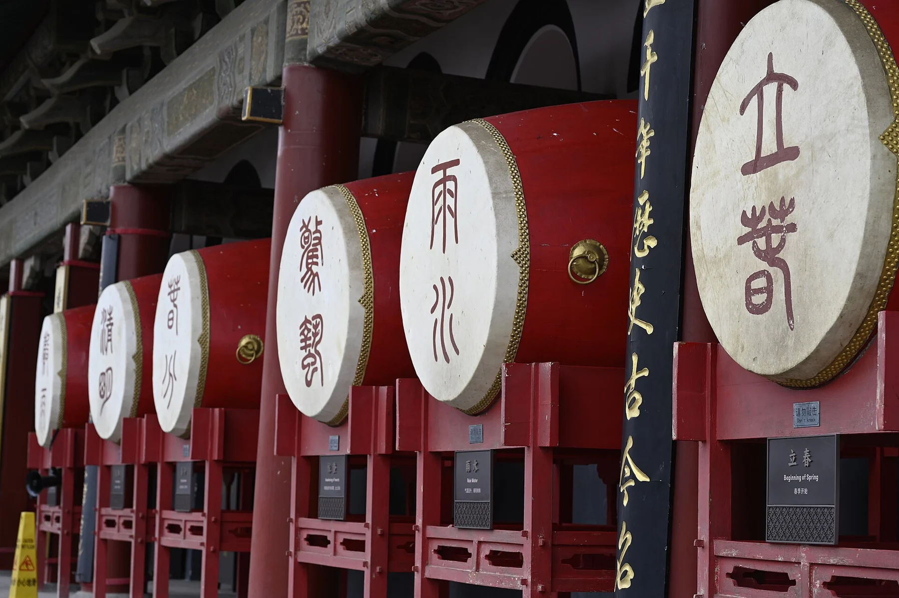 A row of red drums labelled with traditional solar terms including 立春, 雨水 and 惊蛰.