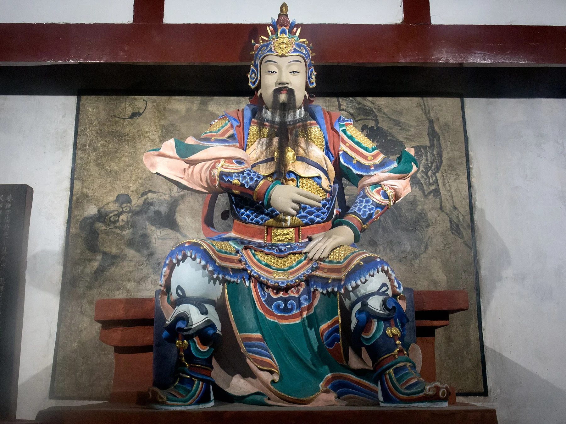 Seated Jiang Wei figure in brightly patterned armour
