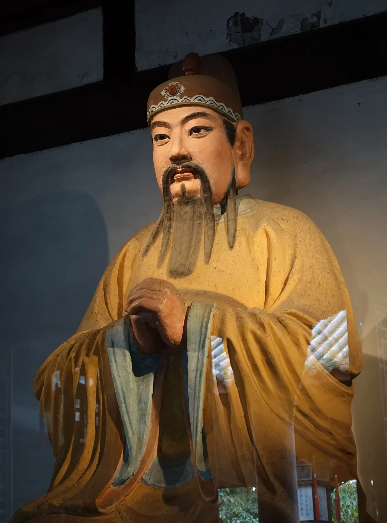 Seated Liu Bei figure in a plain yellow robe and brown cap