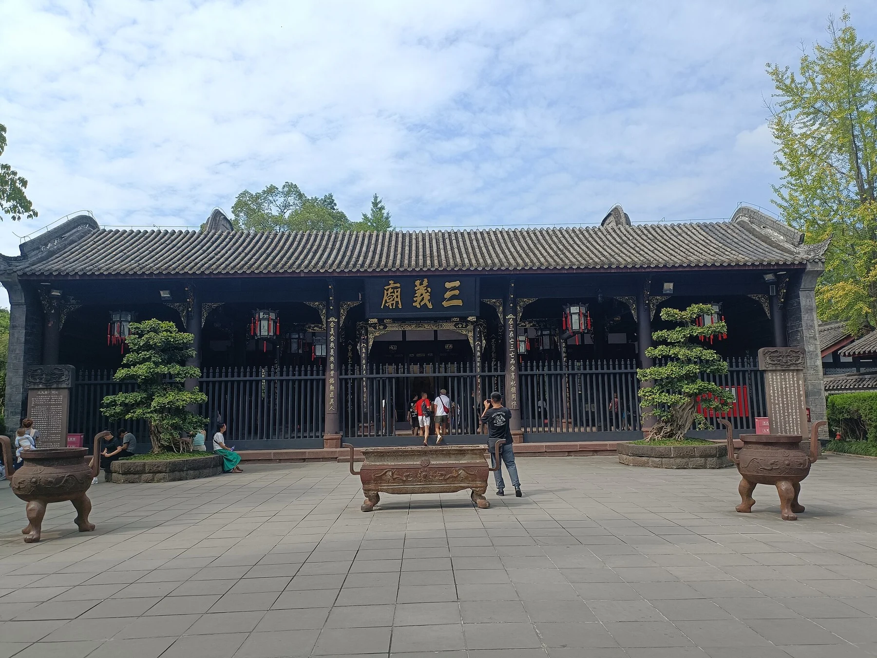 Long timber temple hall across an open courtyard with vessels in front