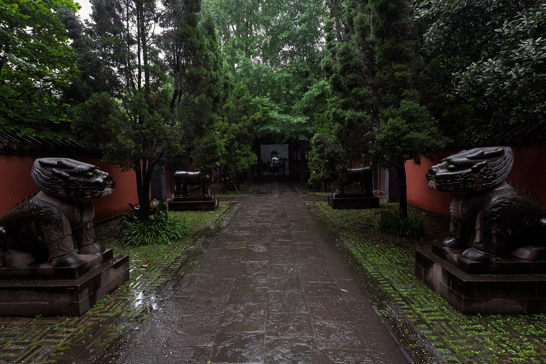 Tree-lined approach with carved stone animals on both sides