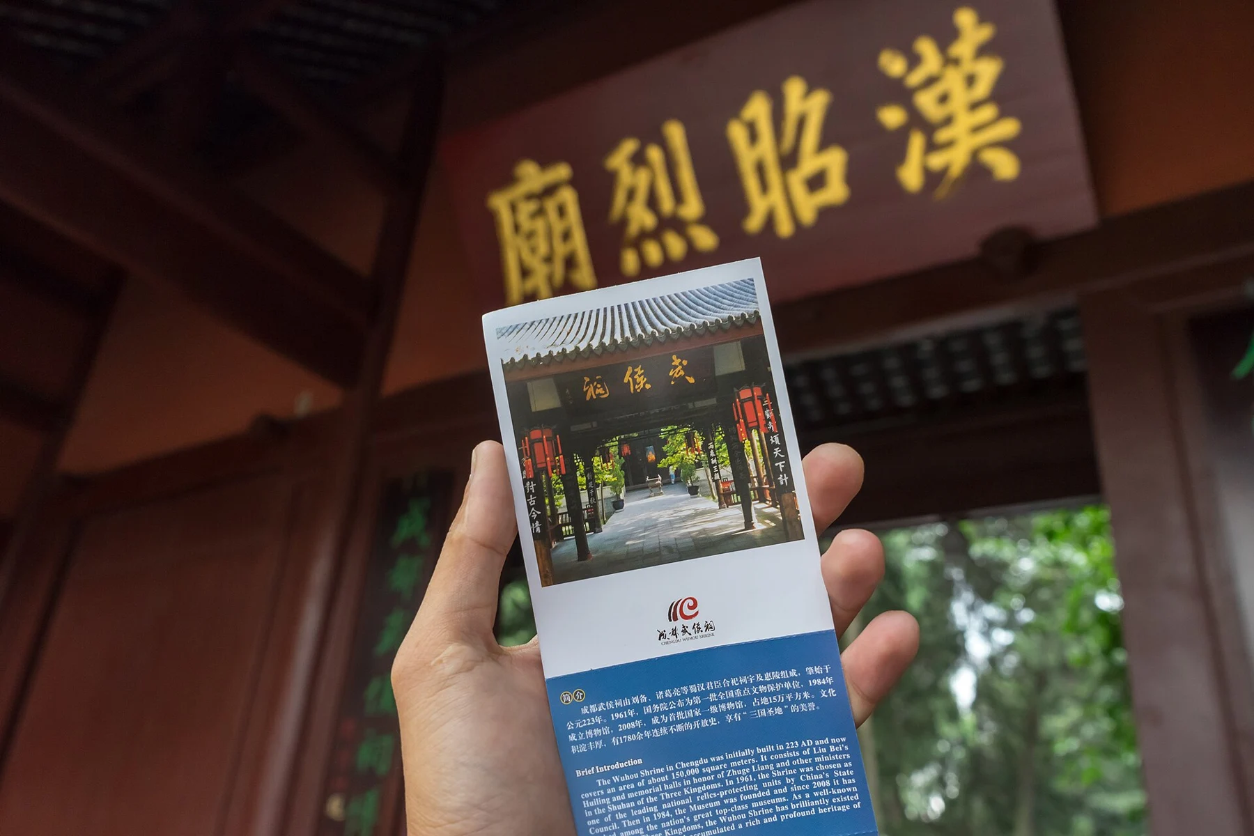 Hand holding an old paper museum ticket beneath the Han Zhaolie Temple plaque