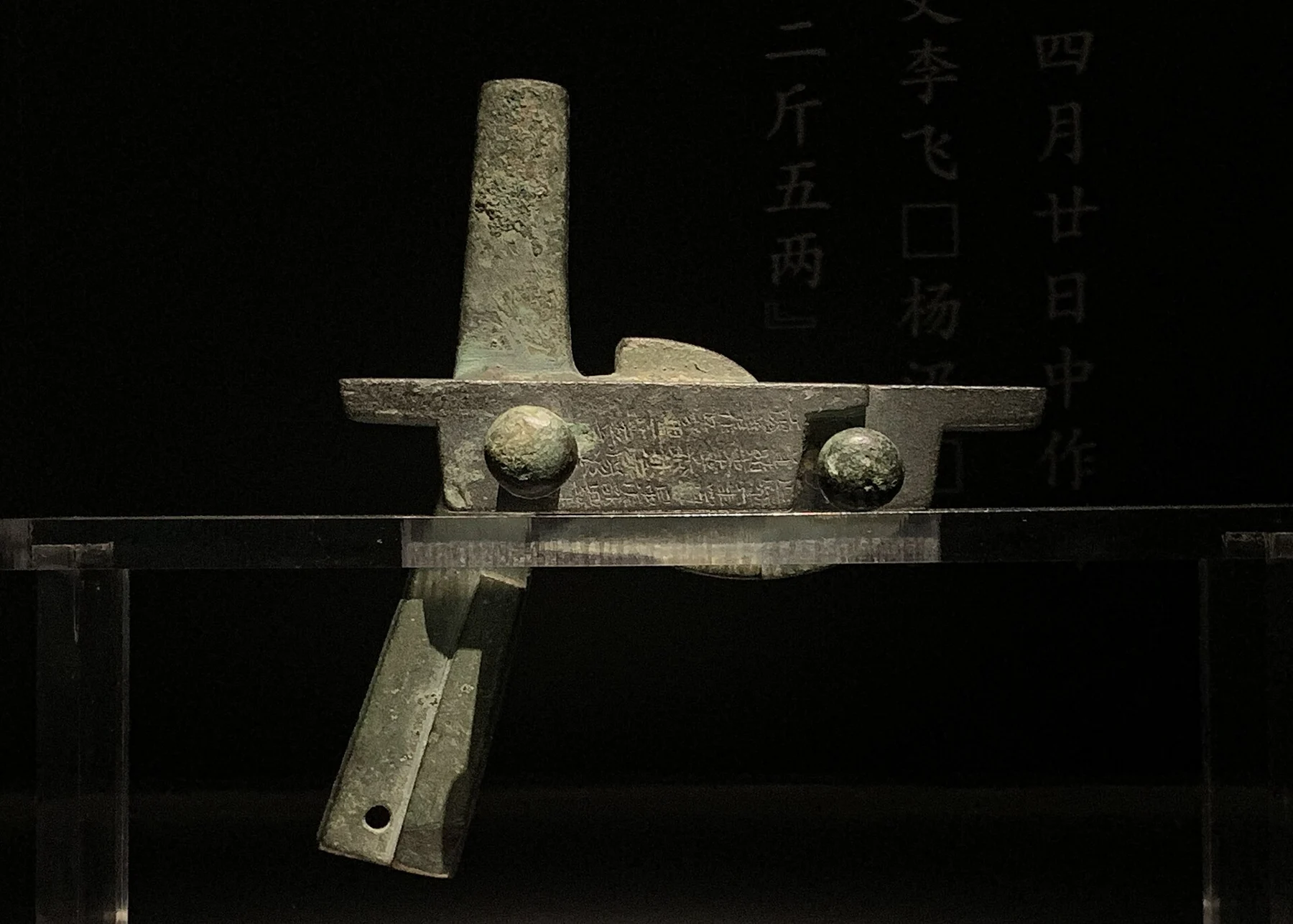 Bronze crossbow-trigger mechanism under display lighting