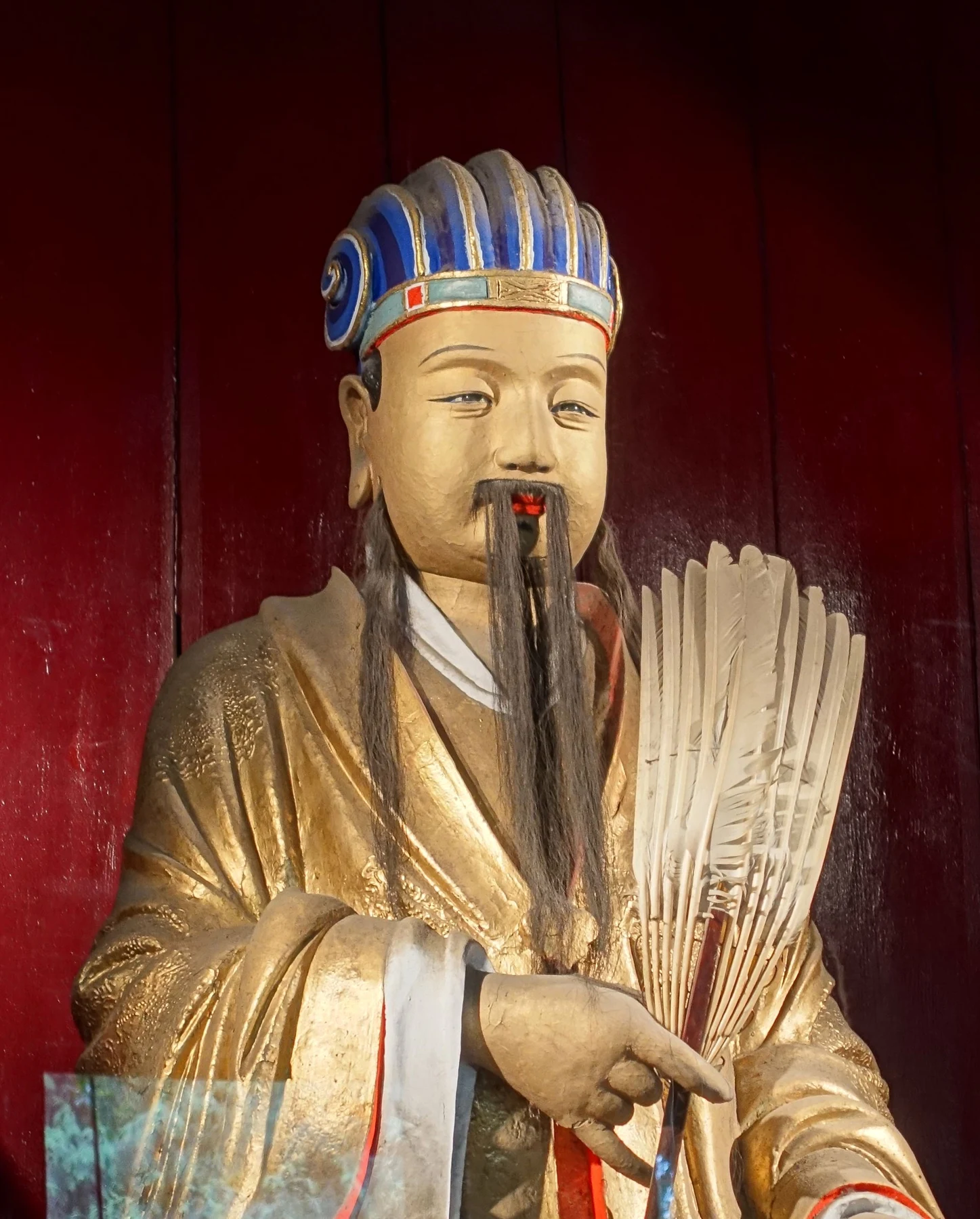 Gilded seated Zhuge Liang holding a feather fan