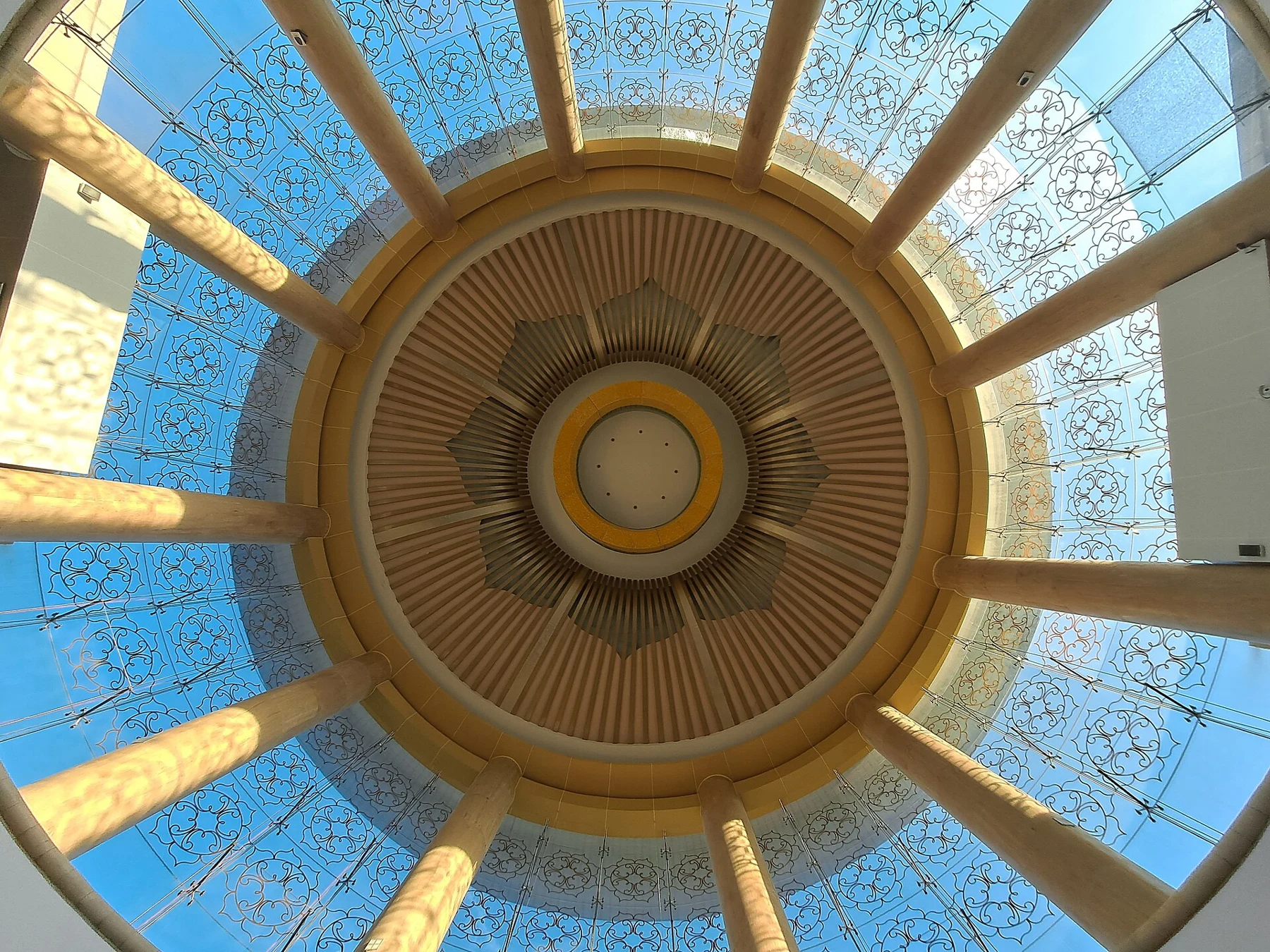 A circular interior roof with radial beams and a glass perimeter.
