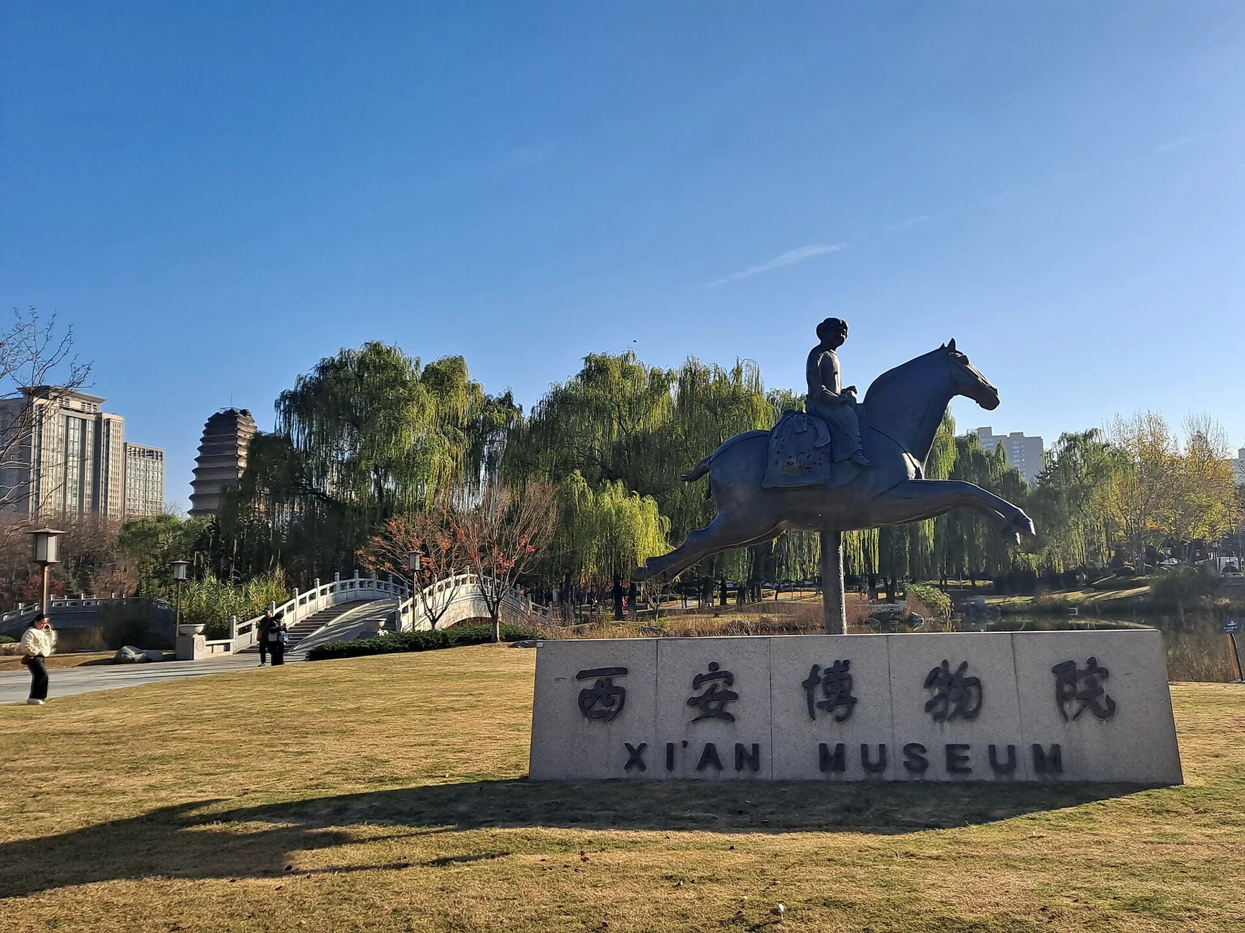 A modern horse-and-rider sculpture above a stone sign reading 西安博物院.