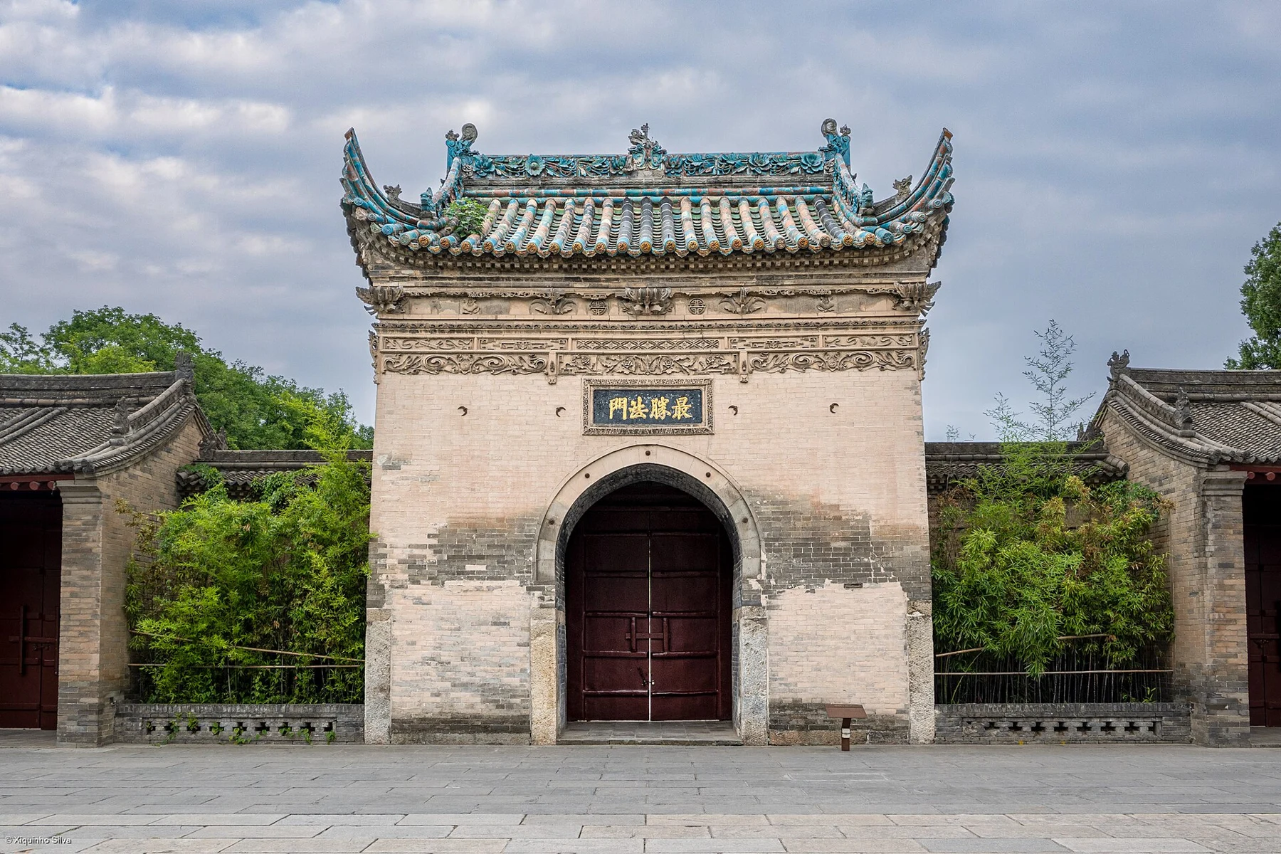 Jianfu Temple’s closed arched gateway under a glazed-tile roof.