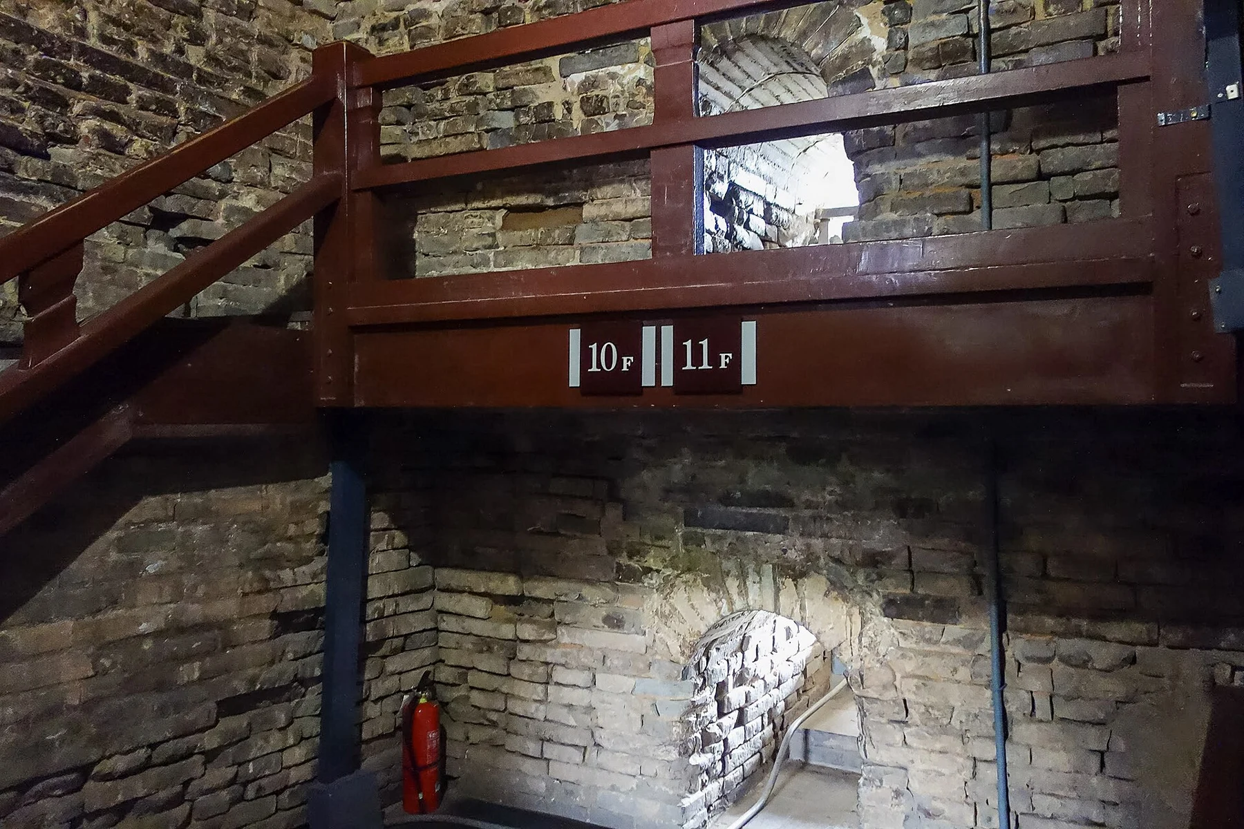 Brick interior, a wooden stair and level signs in an archival photograph of Small Wild Goose Pagoda.