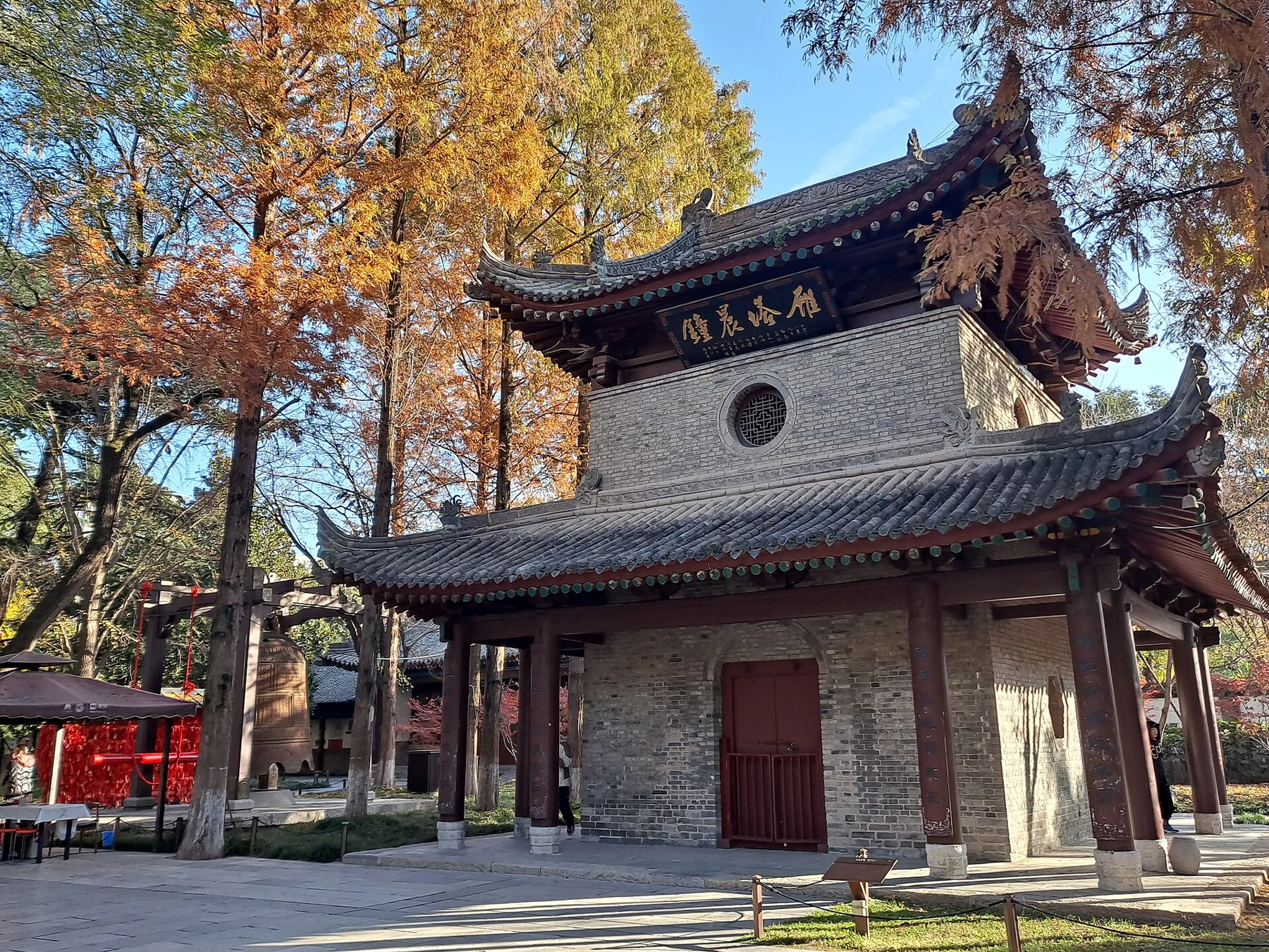 A two-storey raised pavilion with a closed central doorway and the 敕赐荐福寺 plaque.