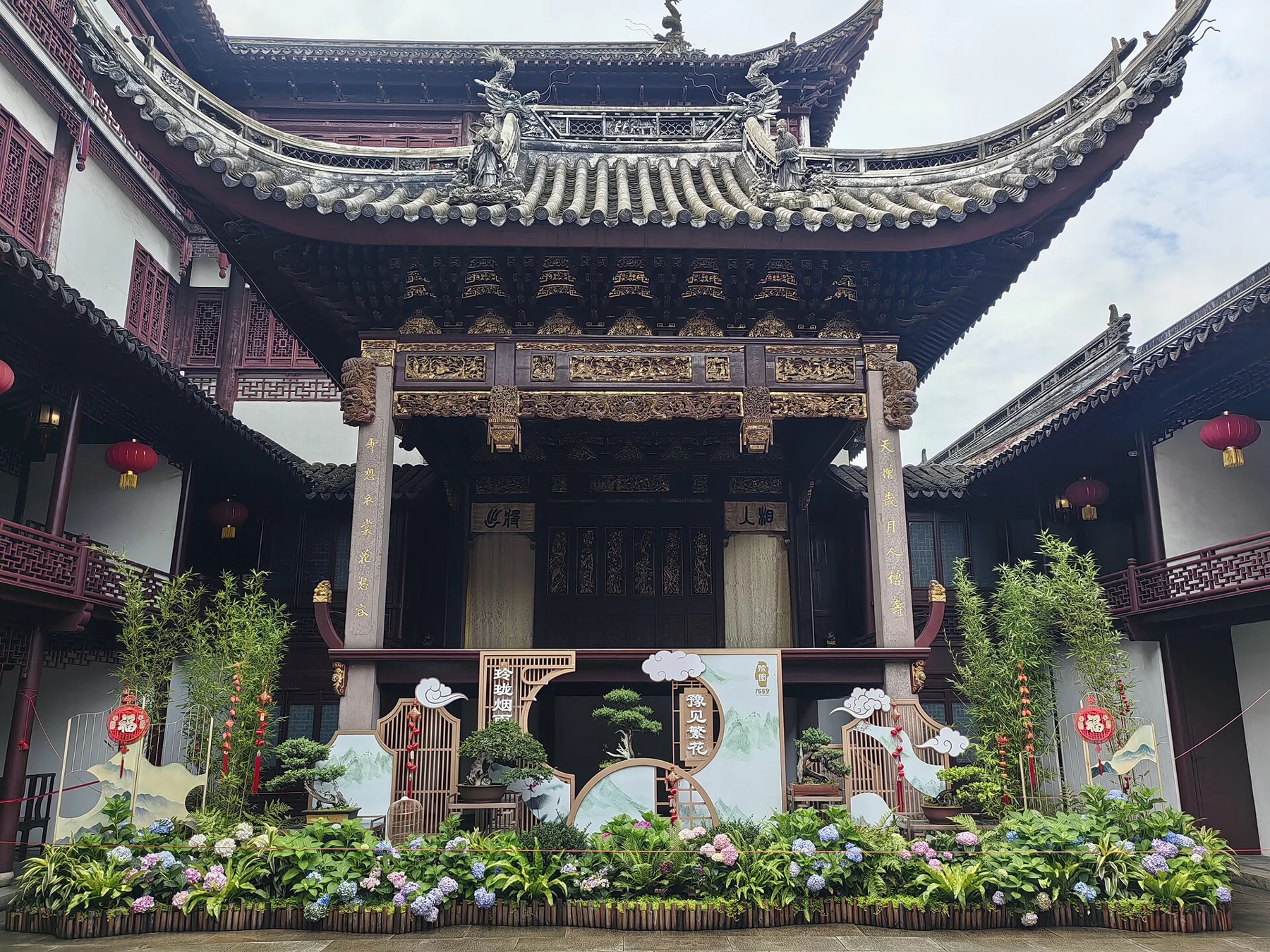 An elaborate stage front beneath tall curved eaves, facing an open courtyard.