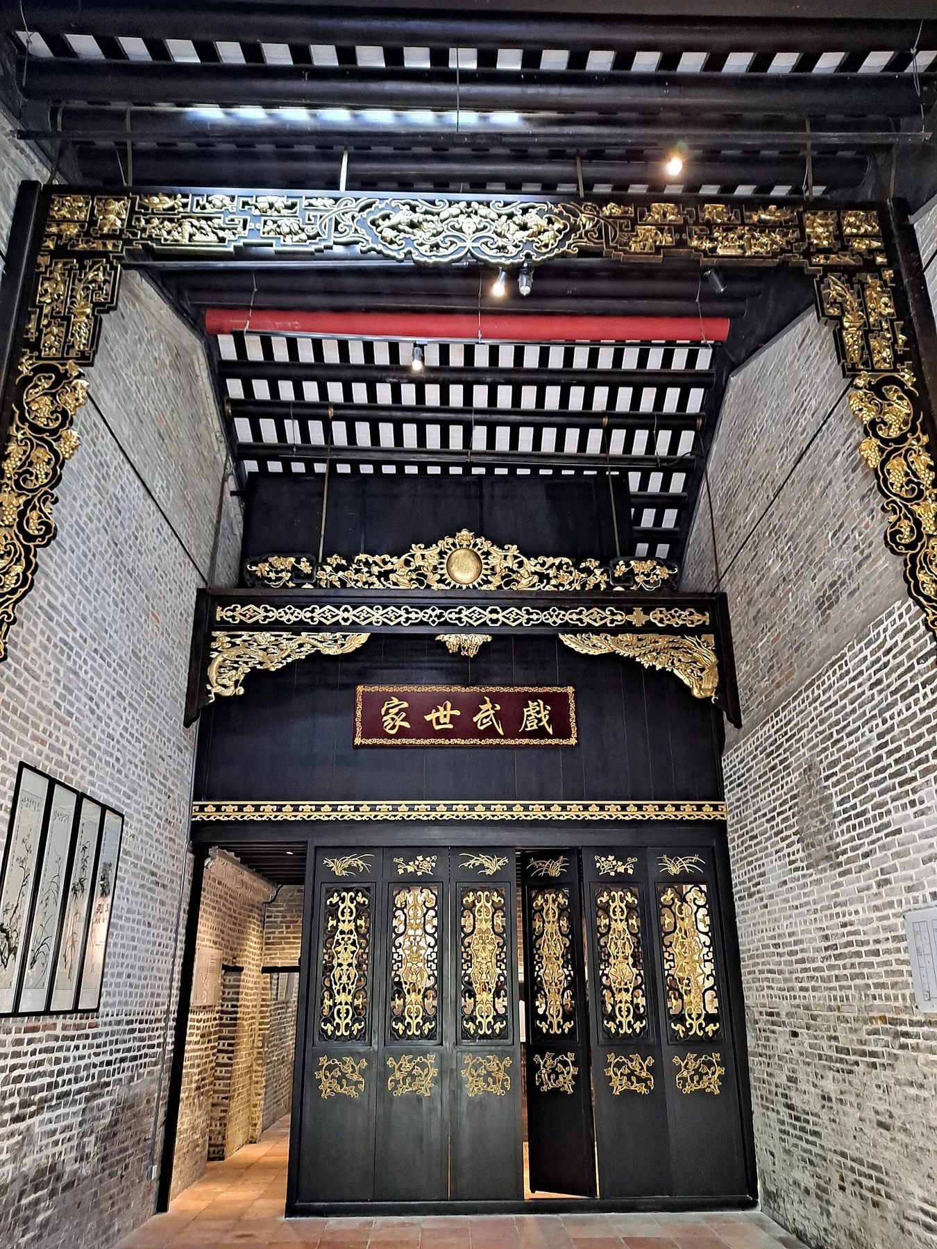 Decorated dark doorway and carved frame inside the Lee family house.
