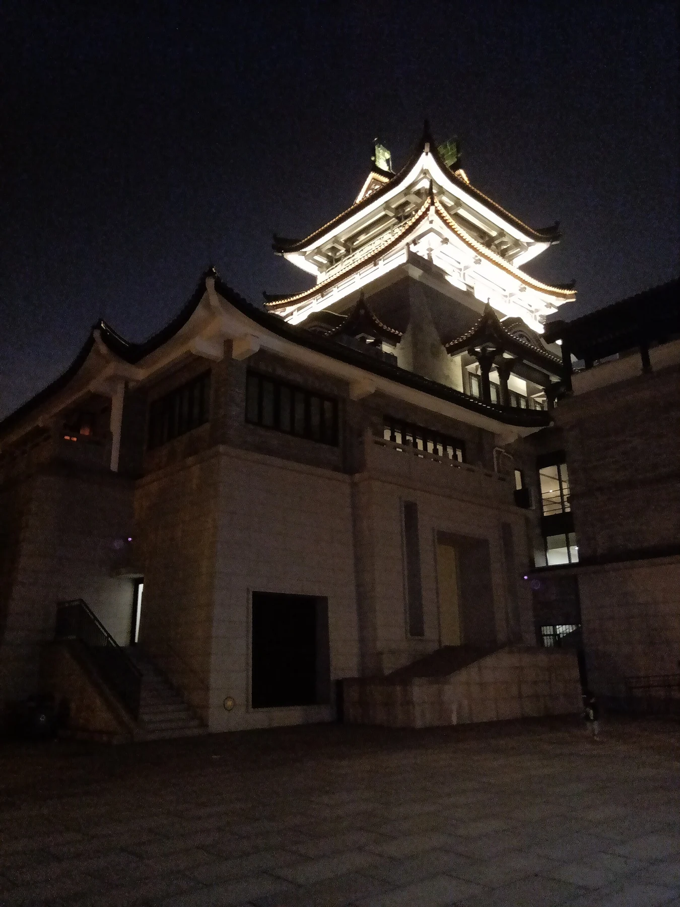 Lit multi-level museum tower and roofline against a dark sky.
