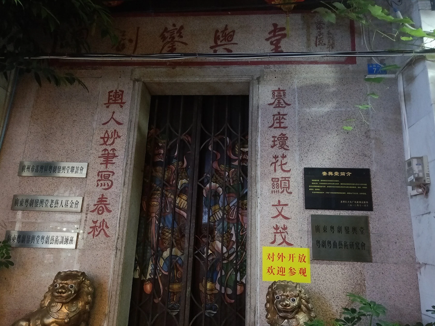 Luan Yu Tang entrance with Chinese inscriptions, a metal gate and a small stone lion.