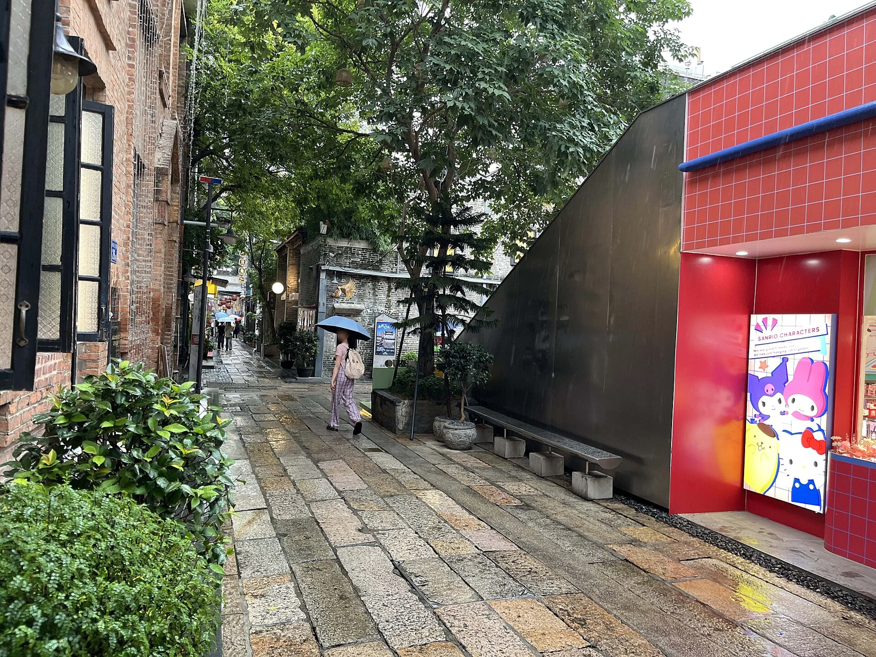 Yongqing Dajie with trees, a paved path and a modern red frontage.